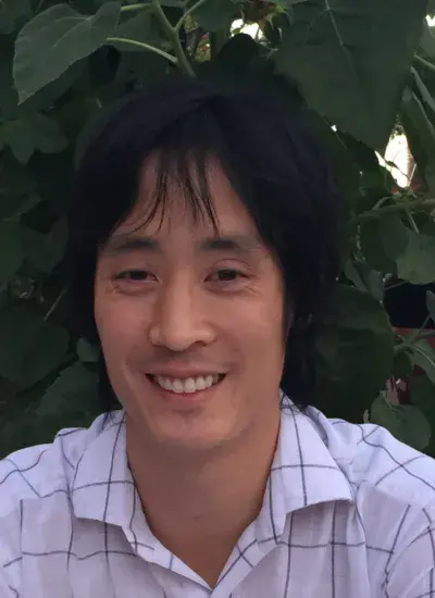 Photo of Steven Dang in front of foliage