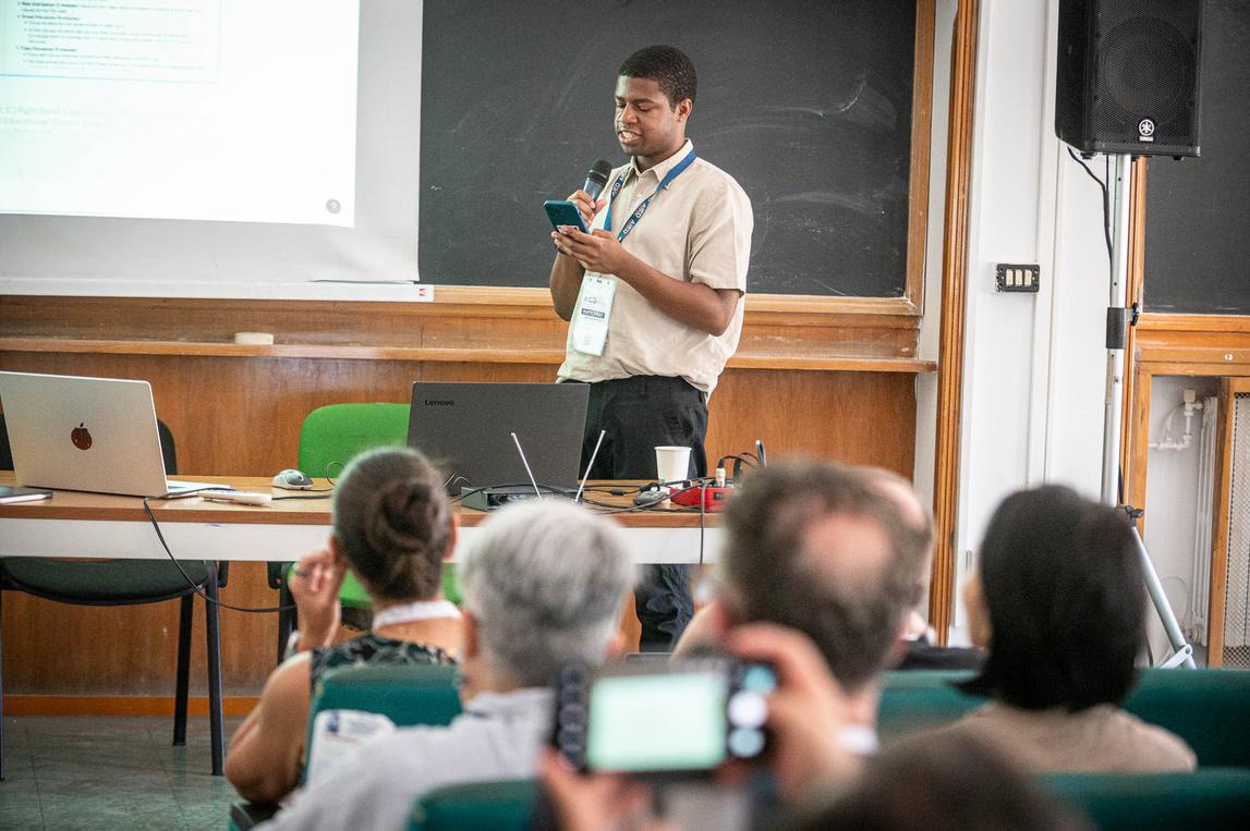 Michael Sutton at the front of a classroom presenting the paper