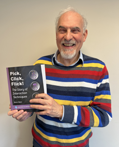 Brad Myers holds a paperback copy of his new book "Pick, Click, Flick! The Story of Interaction Techniques"