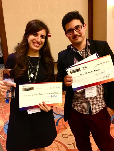 Nesra Yannier and Ken Holstein holding their award checks at the Reimagine Education competition