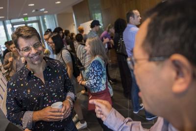Ken Koedinger converses with others in the hallway during the LearnLab summer school poster session