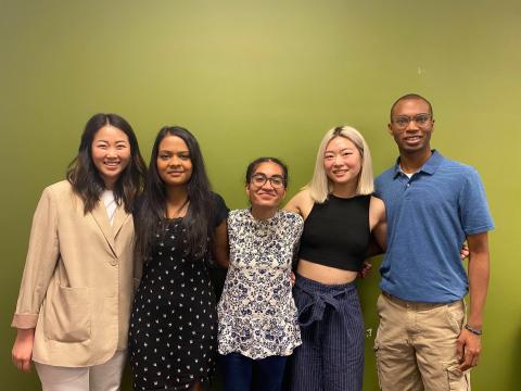 group photo of the 5 students on Team Yasu in front of the infamous MHCI Green Wall