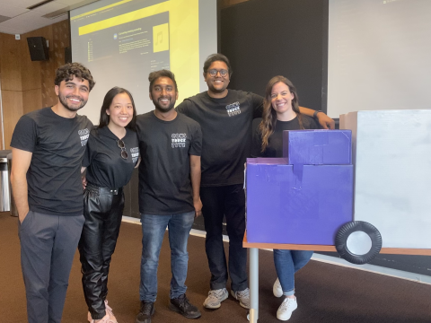 group photo of the 5 students on the Torc team beside a cardboard truck