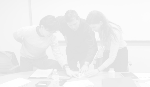 3 members of the team around a table doing visioning exercise