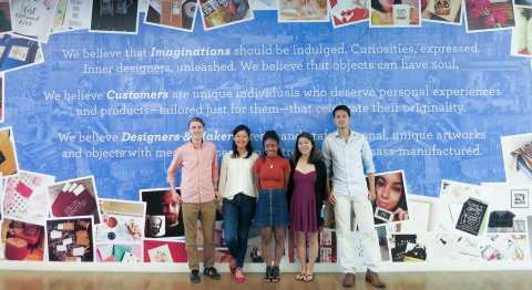 5 team members stand in front of colorful wall with inspirational creativity quote