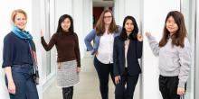 Five female AI researchers stand in the bridge between NSH and Gates 