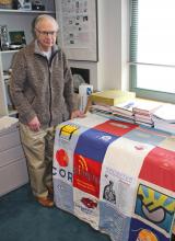 Dan Siewiorek stands beside the t-shirt quilt in his office