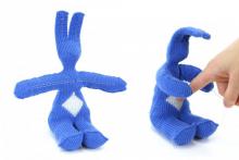 image on left: bunny knit out of blue yarn. image on right: when responsive fibers on belly are poked, bunny responds with hugging motion