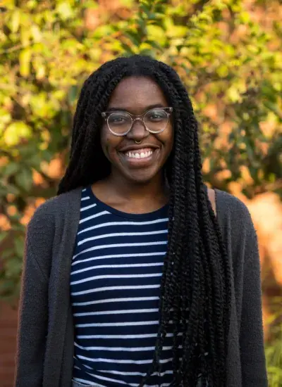 Photo of Lisa Egede in front of green foliage