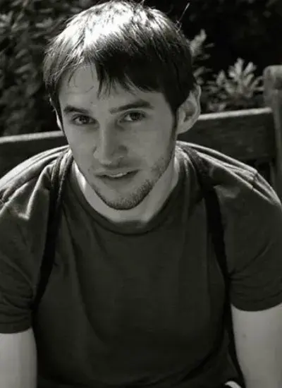 Black and white photo of Michael Rivera sitting on bench