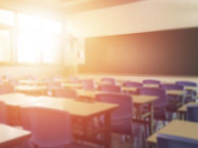an empty classroom with a bright beam of light coming in from the windows on the left side of the room