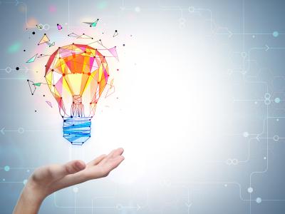 a colorful lightbulb floats above a hand on a blue background