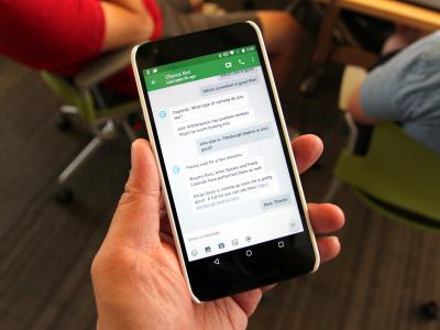 The Evorus chatbot uses humans not only to augment AI, but also to simultaneously train it — gradually reducing the chatbot's dependence on people. a hand holding a mobile phone with the Evorus chat window open
