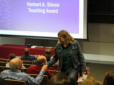 Brad Myers shakes Raelin Musuraca's hand as she walks back to her seat after winning an award