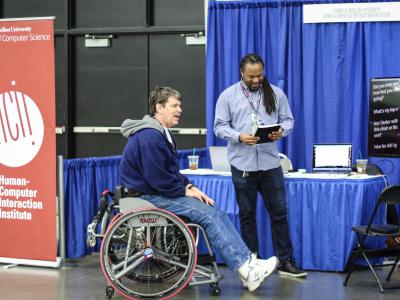 Patrick Carrington speaks with an athlete at the NWBT about SpokeSense