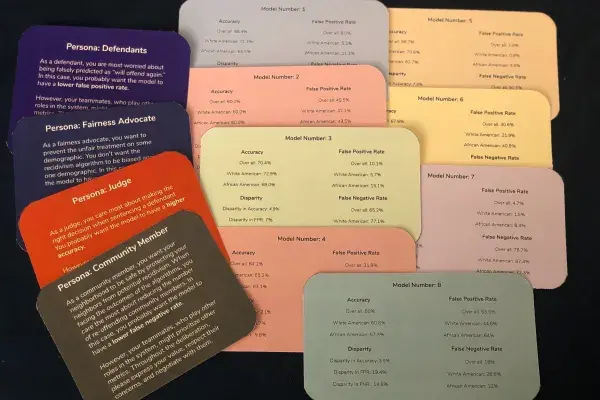 12 cards of various solid colors lay slightly overlapping on a black background