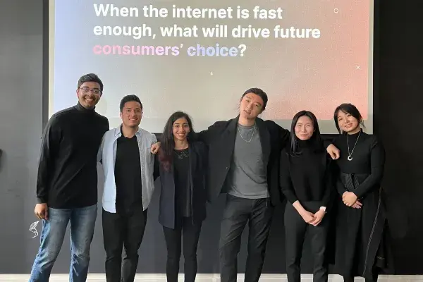 6 students on team InterDigital stand in front of projector screen with text "When the internet is fast enough, what will drive future consumers' choice?"