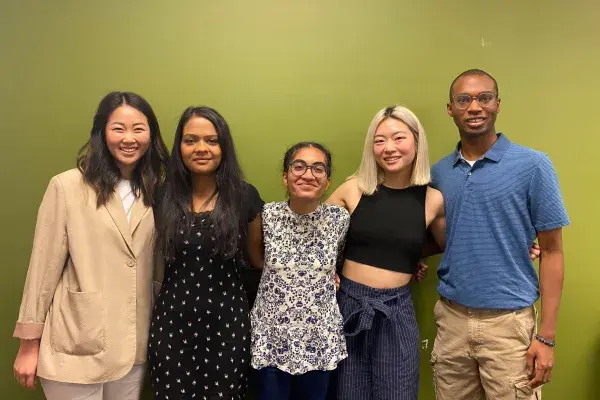 group photo of the 5 students on Team Yasu in front of the infamous MHCI Green Wall