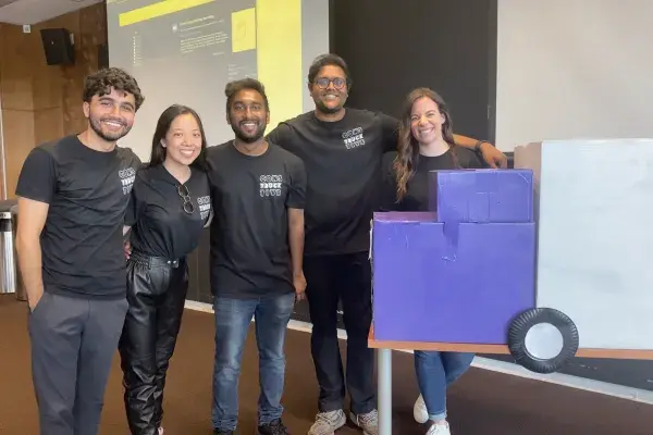 group photo of the 5 students on the Torc team beside a cardboard truck