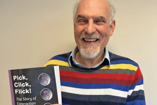 Brad Myers holds a paperback copy of his new book "Pick, Click, Flick! The Story of Interaction Techniques"