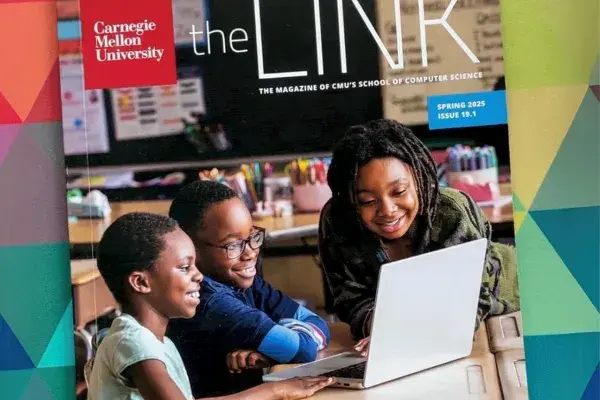 Spring 2025 issue of The Link magazine on a bright background. The front cover photo is of 3 young children facing a laptop while sitting at a desk in a classroom