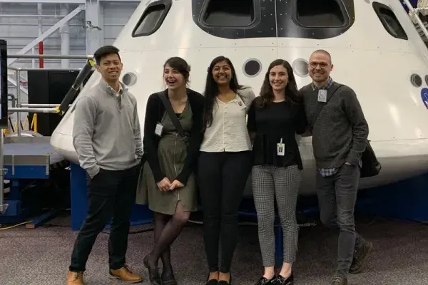 5 students on the NASA team visited Houston and stand in front of space craft