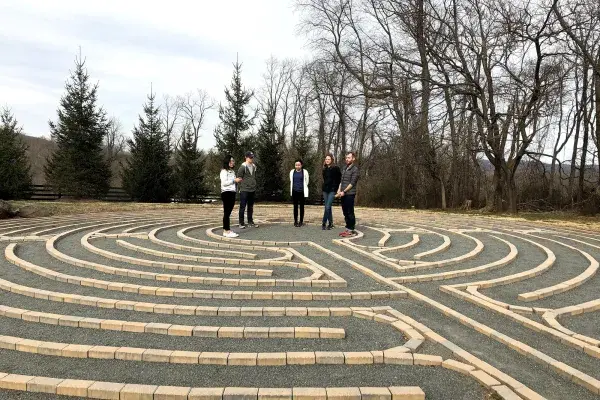 5 students on team Boulder Crest stand in the center of an outdoor labrynth 