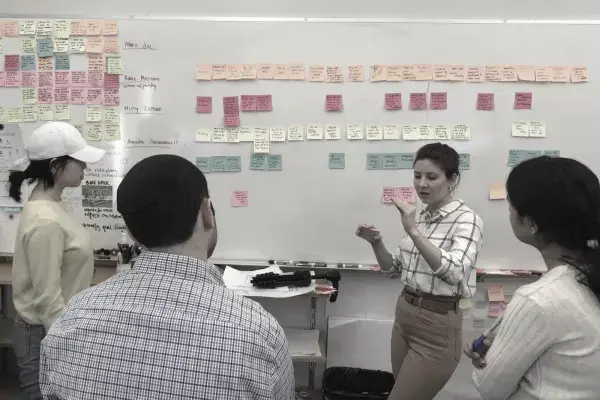 4 members from Nationwide team gather in front of wall of post its while discussing research