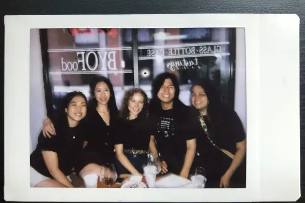 black and white Polaroid photo of the 5 students on this team at a restaurant