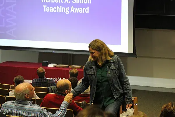 Brad Myers shakes Raelin Musuraca's hand as she walks back to her seat after winning an award