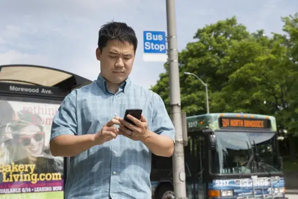 Adrian deFreitas using an Internet of Things app that automatically downloads transit apps when he is near a bus stop.